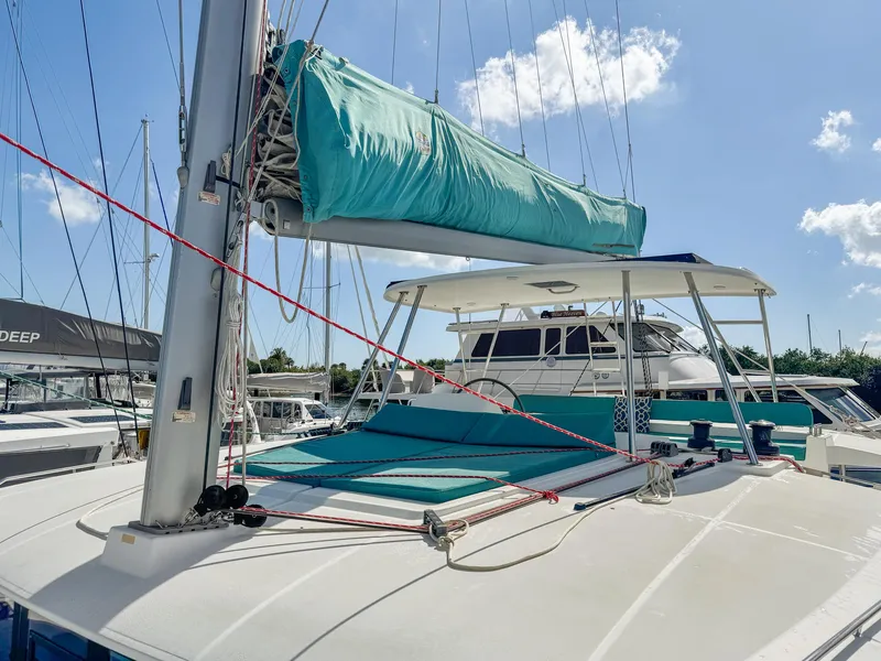 Slide: The Image of 2017 Lagoon 450 F catamaran with turquoise sail cover, docked under a clear sky. - 26