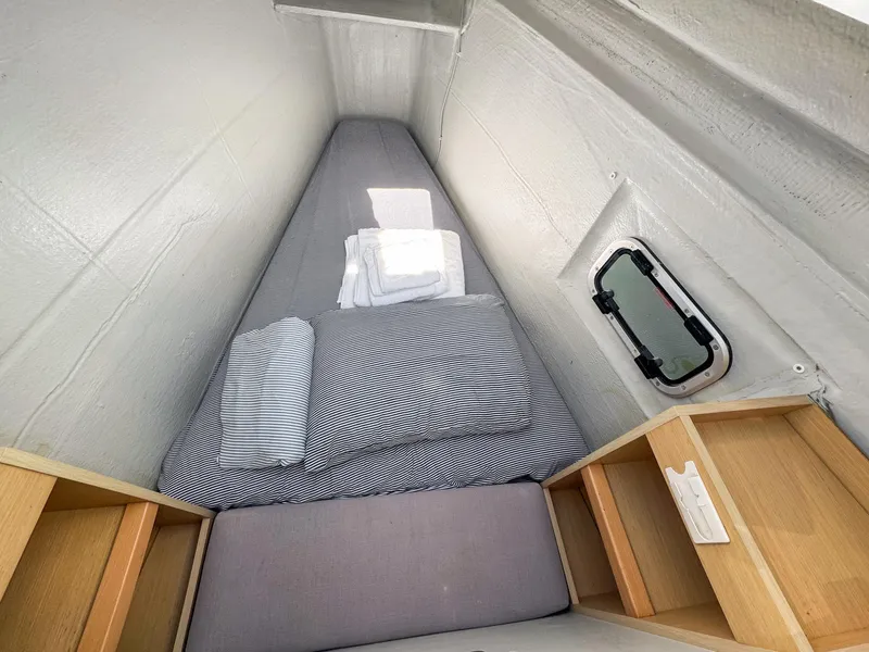 Slide: The Image of 2017 Lagoon 450 F cabin with striped bedding and storage shelves. - 46