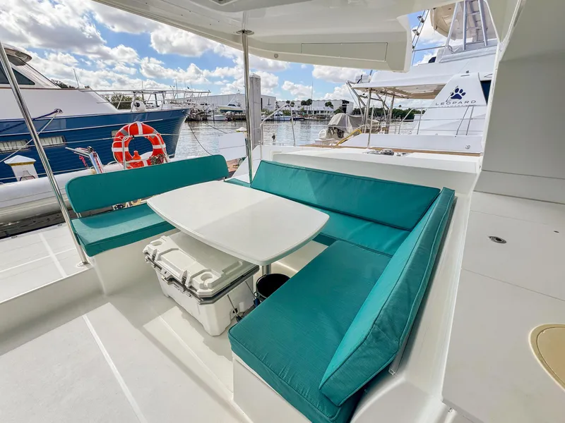 Slide: The Image of Outdoor seating area on 2017 Lagoon 450 F catamaran with turquoise cushions and table. - 6