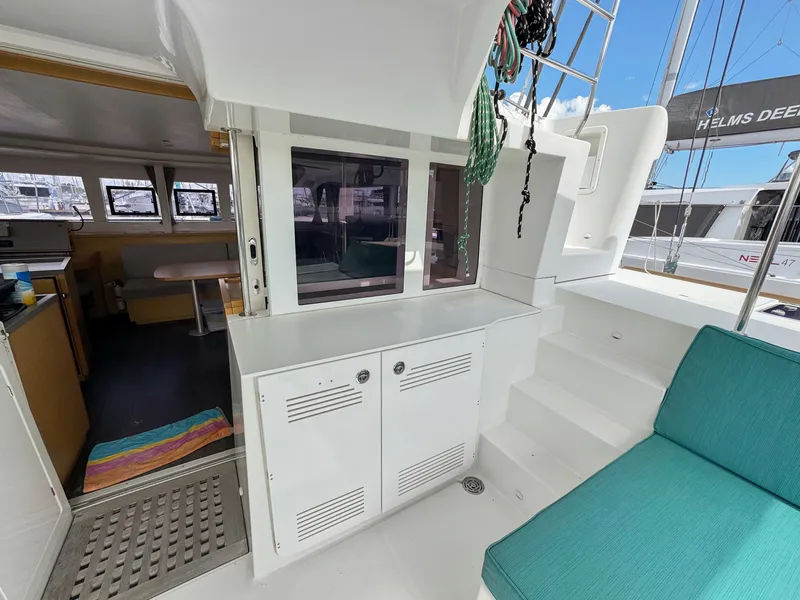 Slide: The Image of 2017 Lagoon 450 F catamaran interior with seating, storage, and steps leading to deck. - 9