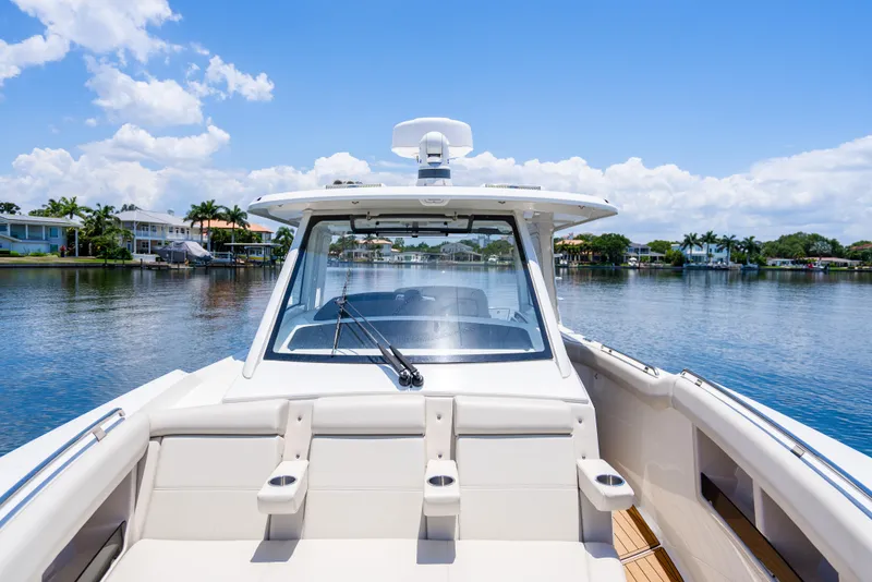 Slide: The Image of 2021 Boston Whaler 350 Realm boat on serene water with clear blue sky. - 20