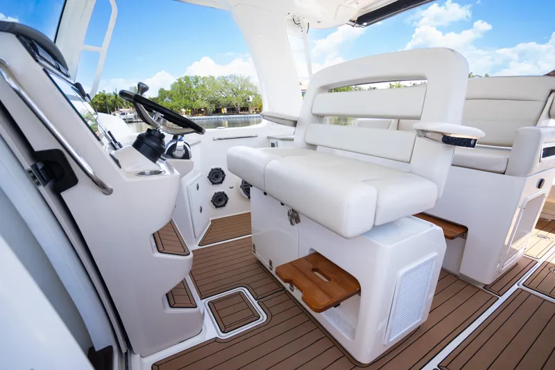 Slide: The Image of 2021 Boston Whaler 350 Realm interior with white seating and wooden flooring. - 21