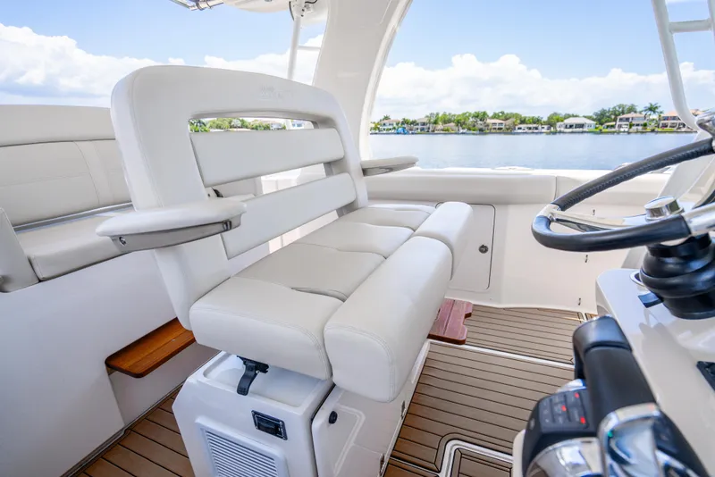 Slide: The Image of 2021 Boston Whaler 350 Realm interior with luxurious seating and steering wheel. - 24