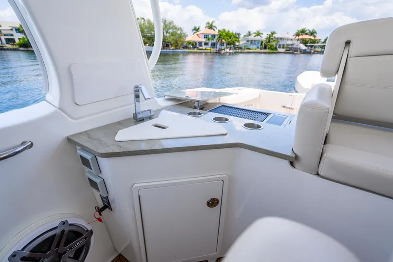 Slide: The Image of 2021 Boston Whaler 350 Realm interior with sleek countertop and seating, overlooking serene waterfront. - 26