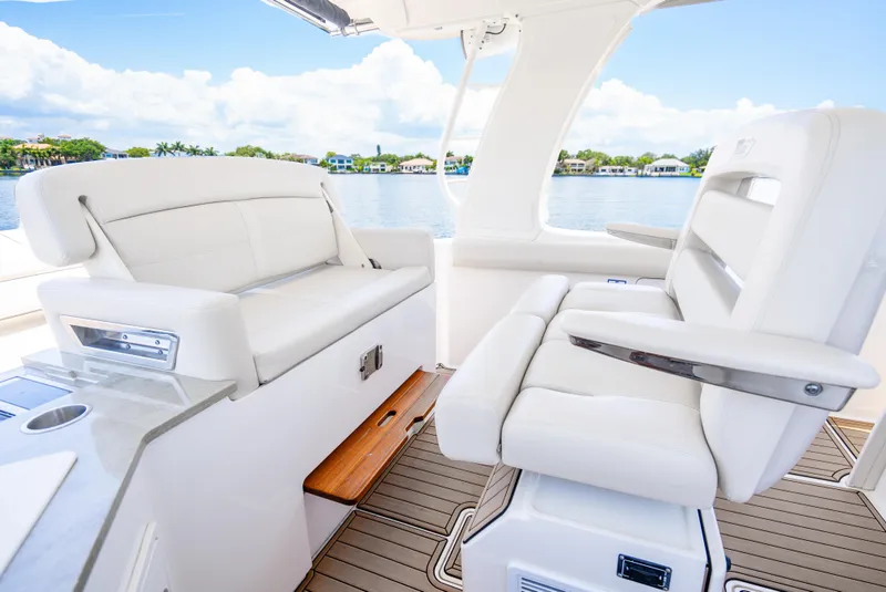 Slide: The Image of 2021 Boston Whaler 350 Realm interior with luxurious white seating and scenic water view. - 27