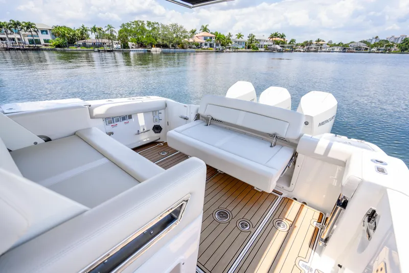 Slide: The Image of 2021 Boston Whaler 350 Realm boat interior with seating, overlooking serene waterfront. - 31