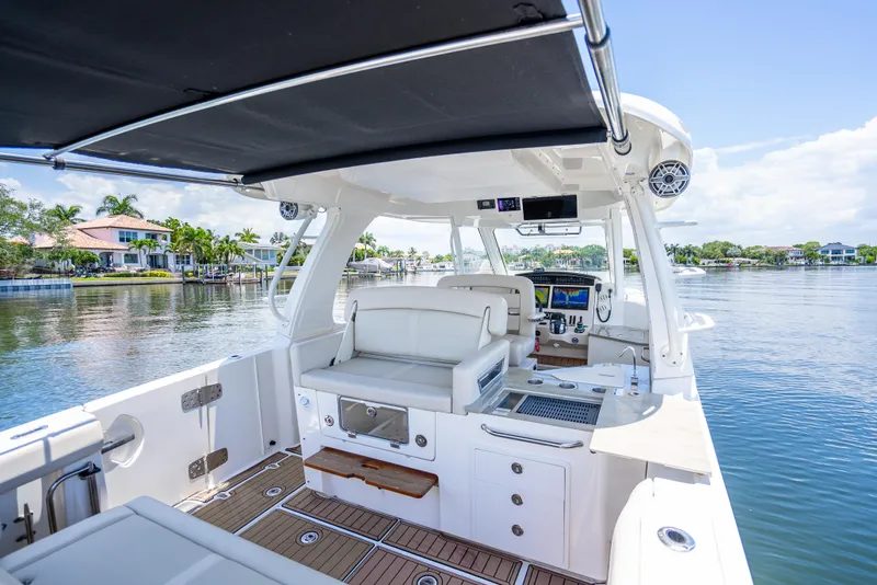 Slide: The Image of 2021 Boston Whaler 350 Realm boat interior with seating and helm, docked on a sunny day. - 34