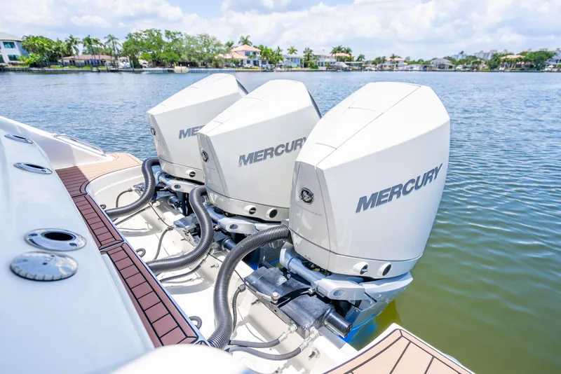 Slide: The Image of 2021 Boston Whaler 350 Realm with triple Mercury outboard engines on a calm lake. - 36
