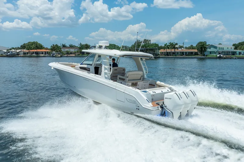 Slide: The Image of 2021 Boston Whaler 350 Realm cruising on a sunny day, showcasing sleek design and powerful engines. - 5