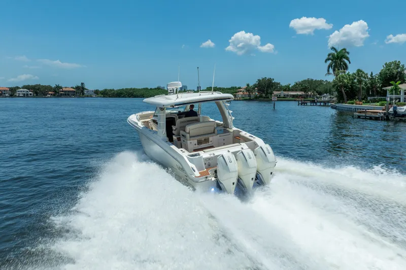 Slide: The Image of 2021 Boston Whaler 350 Realm cruising on a sunny day, showcasing powerful engines and sleek design. - 7