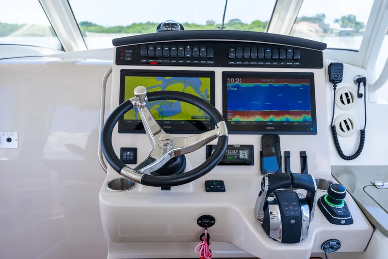 Slide: The Image of Control panel of 2021 Boston Whaler 350 Realm with navigation screens and steering wheel. - 8
