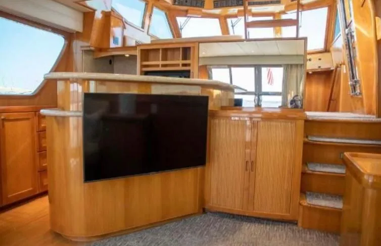 Slide: The Image of Interior of 2005 McKinna 57 Pilothouse yacht with wood cabinetry and large TV. - 7