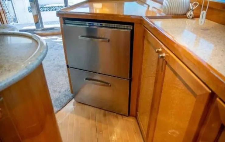 Slide: The Image of 2005 McKinna 57 Pilothouse interior with stainless steel drawers and wooden cabinetry. - 8