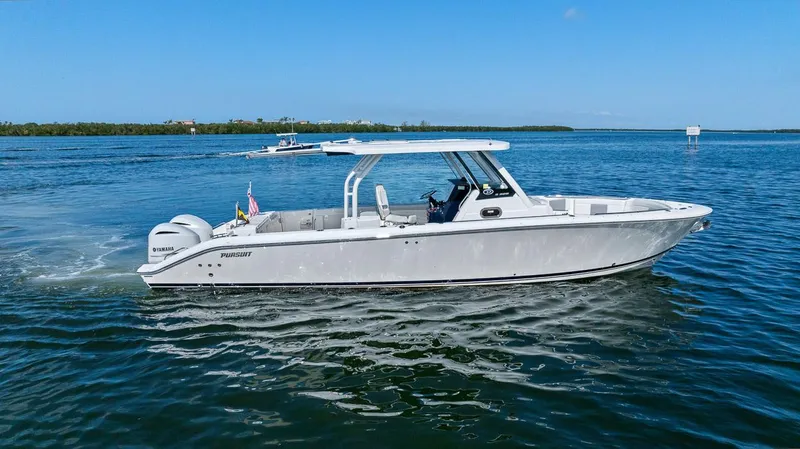 Slide: The Image of 2021 Pursuit S 328 Sport boat cruising on a calm, scenic waterway. - 10