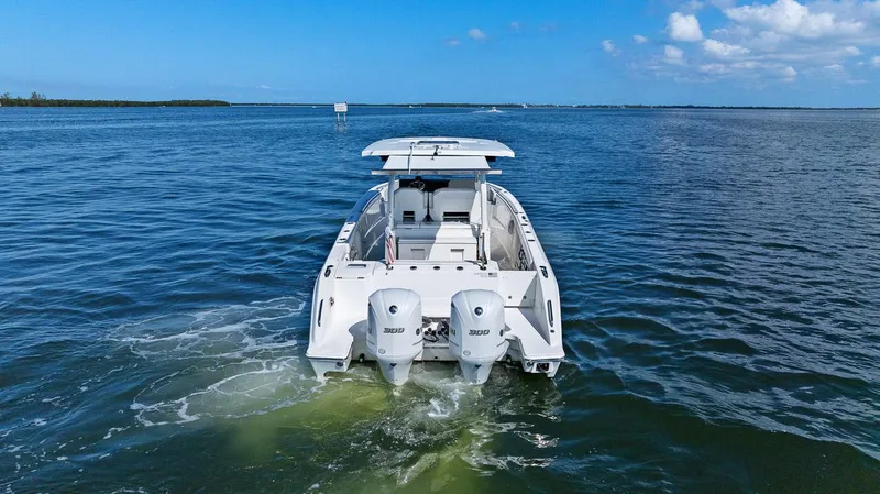 Slide: The Image of 2021 Pursuit S 328 Sport boat on open water, rear view with dual engines. - 12
