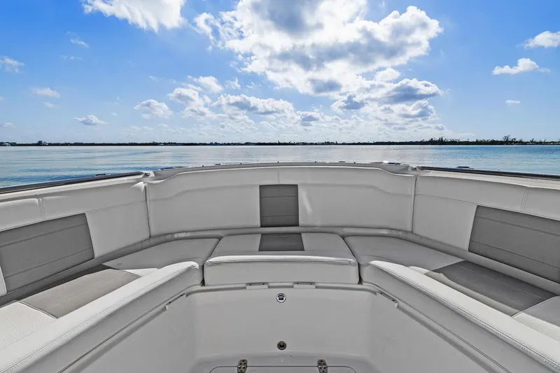 Slide: The Image of 2021 Pursuit S 328 Sport boat interior with cushioned seating, ocean view, and blue sky. - 14
