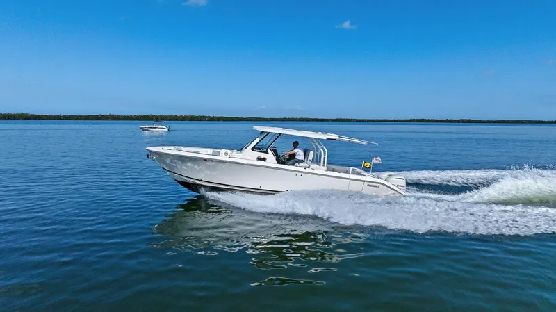 Slide: The Image of 2021 Pursuit S 328 Sport boat cruising on calm blue water. - 17