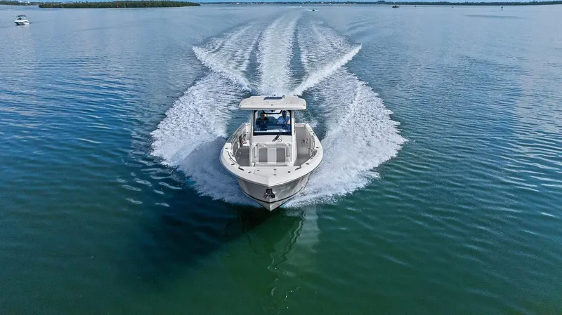 Slide: The Image of 2021 Pursuit S 328 Sport boat cruising on calm water, leaving a wake behind. - 19
