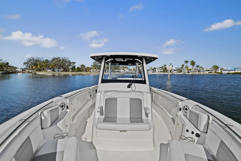 Slide: The Image of 2021 Pursuit S 328 Sport boat on calm water, featuring spacious seating and modern design. - 20