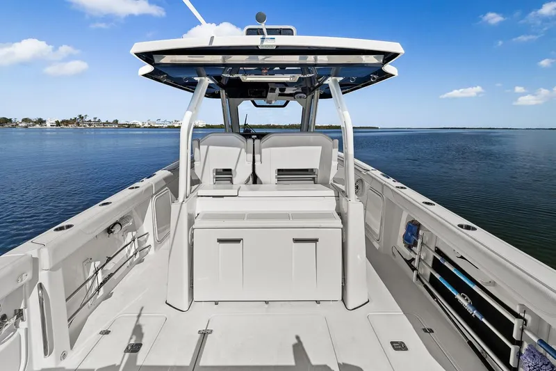 Slide: The Image of 2021 Pursuit S 328 Sport boat on calm water, showcasing spacious deck and seating. - 27