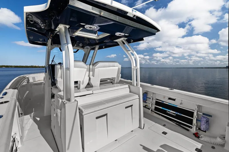 Slide: The Image of 2021 Pursuit S 328 Sport boat interior with seating, under a blue sky. - 28