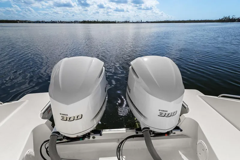 Slide: The Image of 2021 Pursuit S 328 Sport boat with twin 300 horsepower engines on a calm lake. - 30
