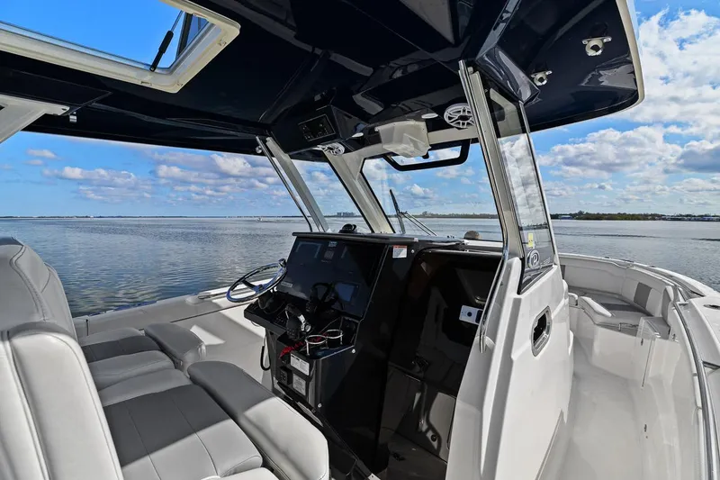 Slide: The Image of 2021 Pursuit S 328 Sport boat interior with helm, seats, and ocean view. - 33