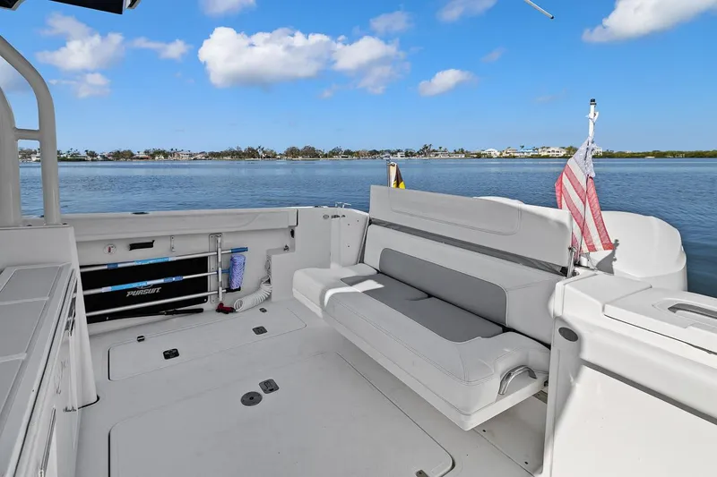 Slide: The Image of 2021 Pursuit S 328 Sport boat interior with seating, overlooking calm waters. - 4
