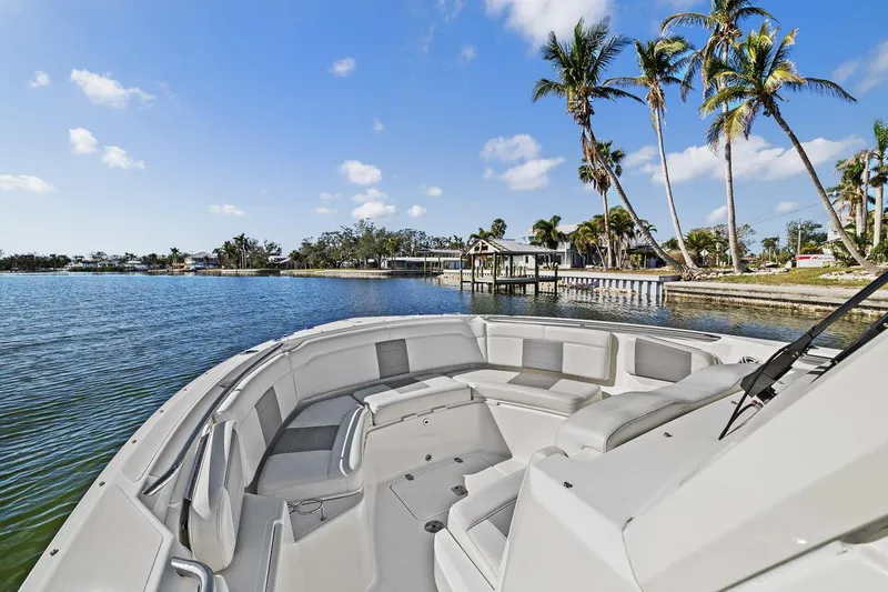Slide: The Image of 2021 Pursuit S 328 Sport boat on a scenic waterfront with palm trees. - 40