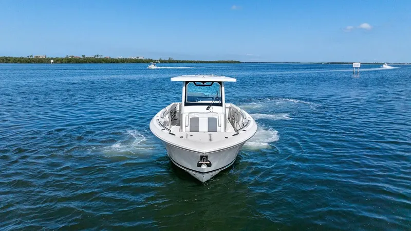 Slide: The Image of 2021 Pursuit S 328 Sport boat cruising on open water under clear blue skies. - 8