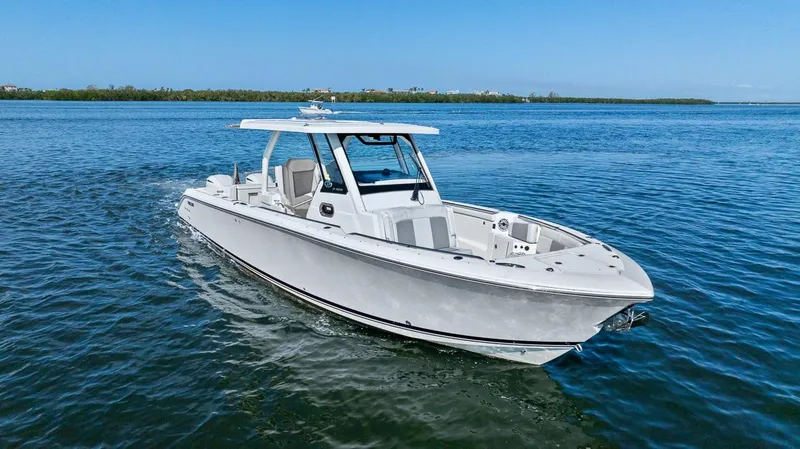 Slide: The Image of 2021 Pursuit S 328 Sport boat cruising on clear blue water. - 9
