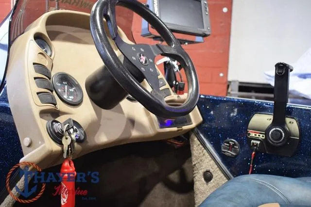 Slide: The Image of Interior of a 2000 Ranger R83 boat with steering wheel and control panel. - 23