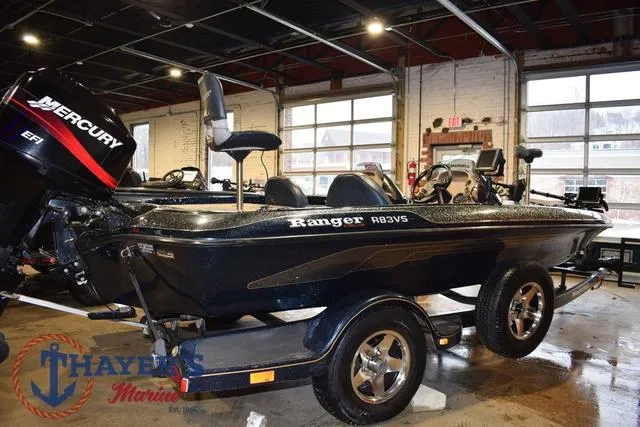 Slide: The Image of 2000 Ranger R83 boat with Mercury engine in showroom, Thayer's Marine logo visible. - 5