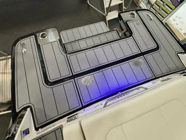 Slide: The Image of 2024 Chaparral 287 SSX boat deck with sleek gray design and blue LED lighting. - 10