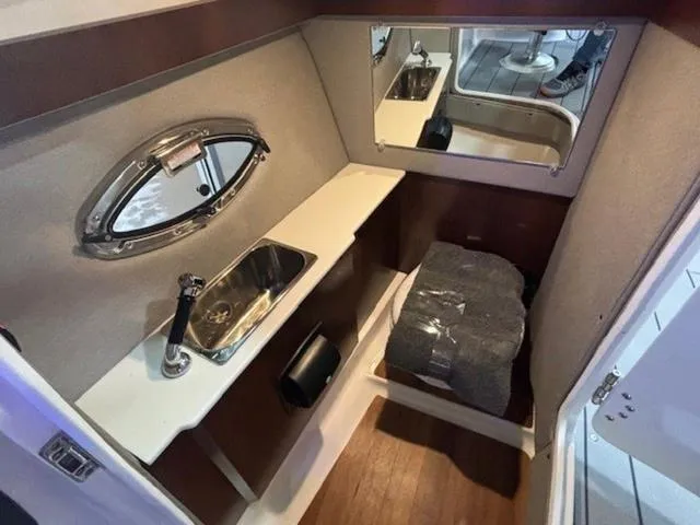 Slide: The Image of 2024 Chaparral 287 SSX cabin interior with sink, mirror, and seating area. - 13