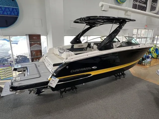 Slide: The Image of 2024 Chaparral 287 SSX boat displayed in showroom, featuring sleek black and yellow design. - 21