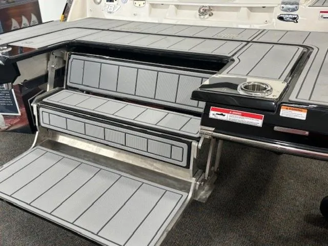 Slide: The Image of 2024 Chaparral 287 SSX boat swim platform with gray non-slip surface and cup holder. - 3