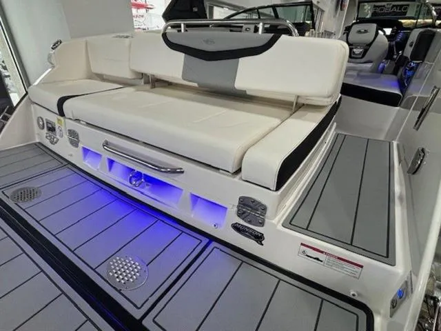 Slide: The Image of 2024 Chaparral 287 SSX boat interior with cushioned seating and blue LED lighting. - 9