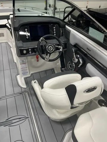 Slide: The Image of 2024 Chaparral 267 SSX boat interior with modern dashboard and white seating. - 10