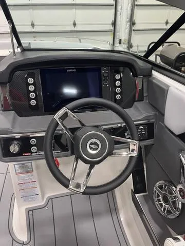 Slide: The Image of 2024 Chaparral 267 SSX boat dashboard with steering wheel and control panel. - 11