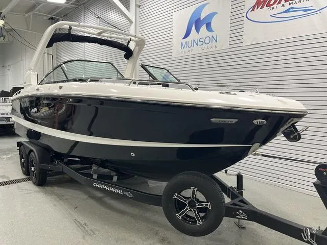 Slide: The Image of 2024 Chaparral 267 SSX boat on trailer in showroom, Munson Surf & Wake signage. - 2