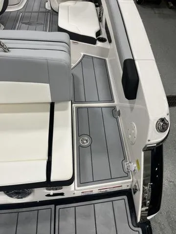 Slide: The Image of 2024 Chaparral 267 SSX boat interior with sleek gray and white seating and flooring. - 6