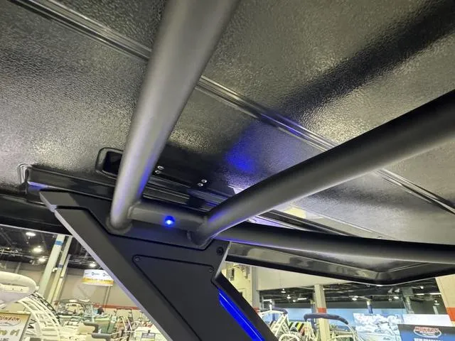 Slide: The Image of 2025 Chaparral 2870 SSX boat interior with sleek metal framework and blue lighting. - 14