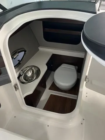 Slide: The Image of 2025 Chaparral 307 SSX boat interior with compact bathroom and sink. - 11