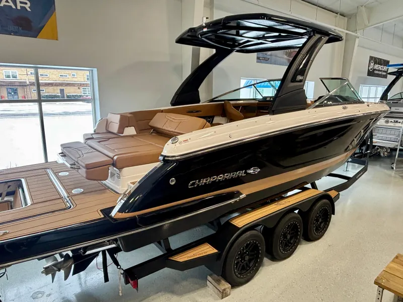 Slide: The Image of 2025 Chaparral 307 SSX boat on trailer in showroom, featuring sleek design and luxury seating. - 1