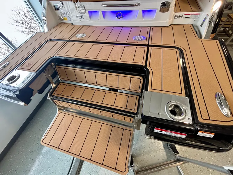 Slide: The Image of 2025 Chaparral 307 SSX boat deck with teak-style flooring and stainless steel accents. - 15