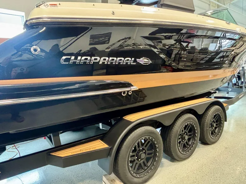 Slide: The Image of 2025 Chaparral 307 SSX boat on a triple-axle trailer in a showroom. - 17