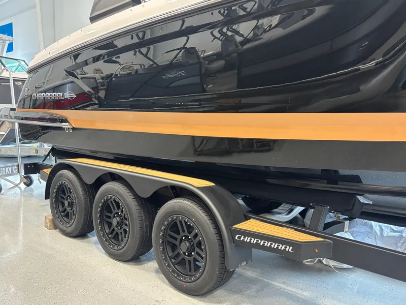 Slide: The Image of 2025 Chaparral 307 SSX boat on a triple-axle trailer in showroom. - 4