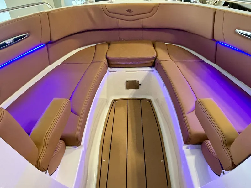 Slide: The Image of Luxurious 2025 Chaparral 307 SSX boat interior with brown seating and blue LED lighting. - 6