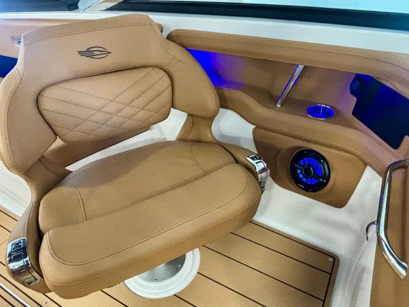 Slide: The Image of 2025 Chaparral 307 SSX boat interior with tan leather seat and blue LED lighting. - 7